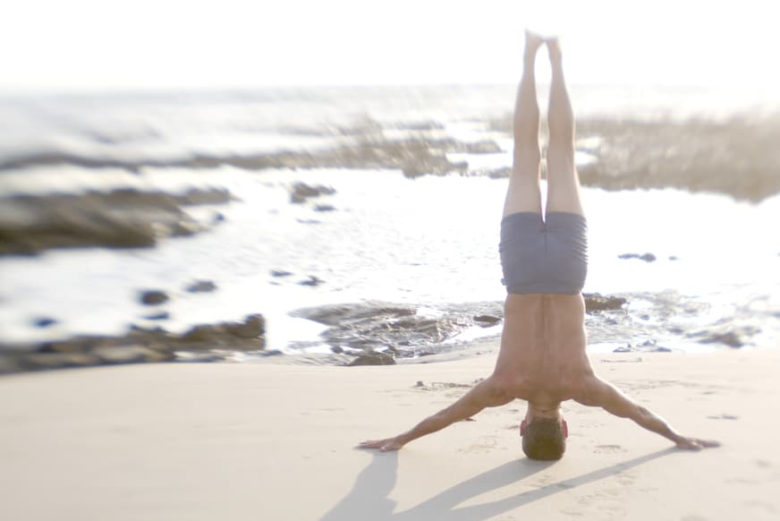 Man Practicing Yoga On The Beach Rheuma Akademie